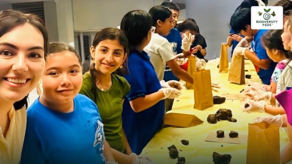 Children and an educator making seed pods together at a workshop